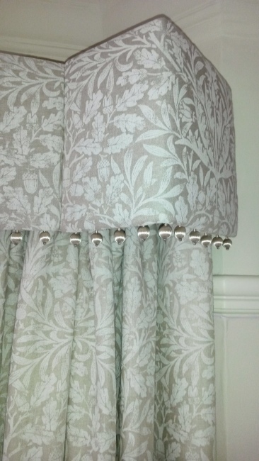 Straight pelmet with pop pom trim in bay window. Morris and Co Pure fabric